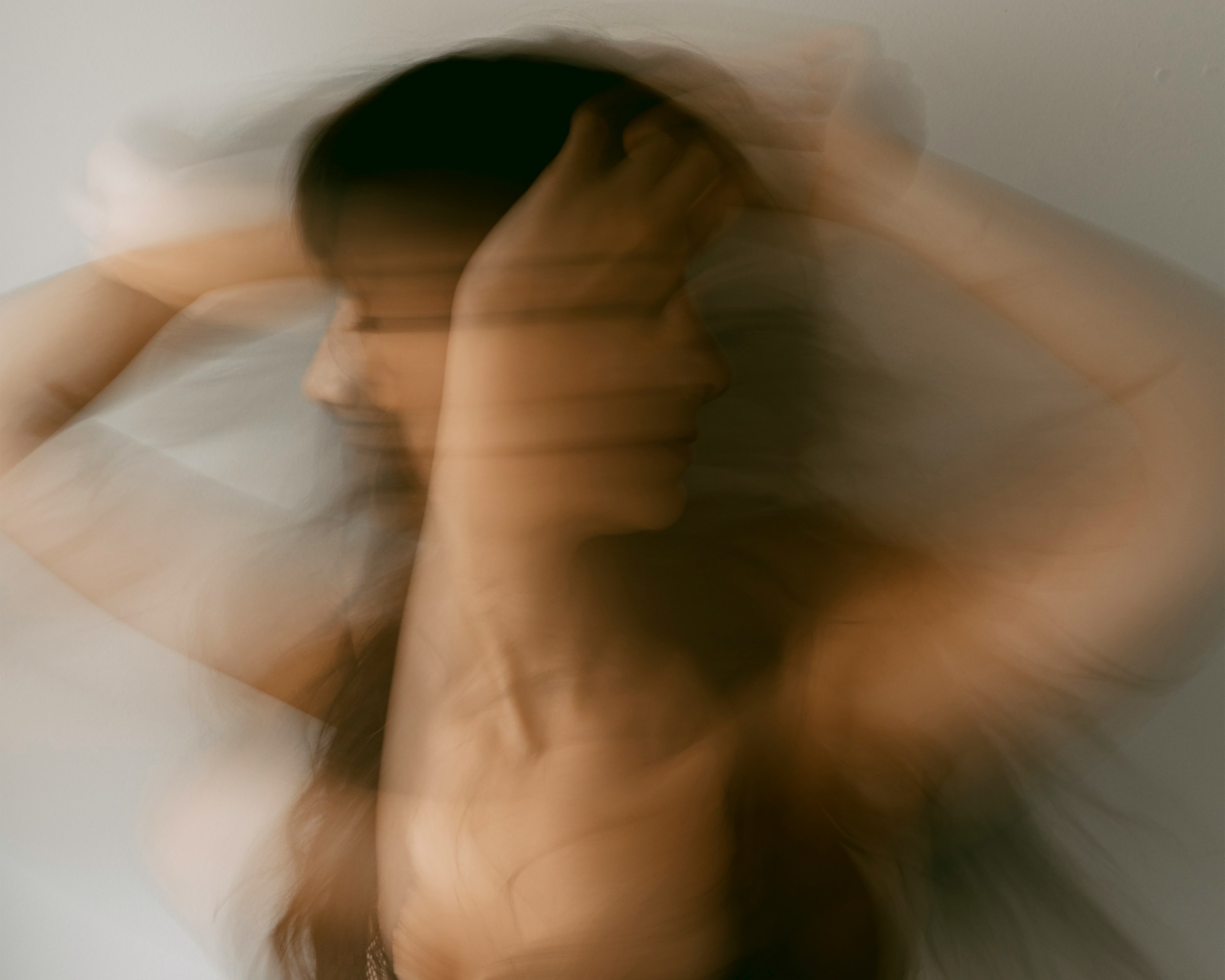 Blurred image of a woman shaking her head in distress.